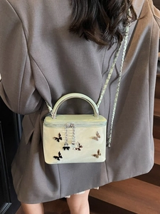 Pale green patent leather bow handbag with silver handle and metallic chain strap