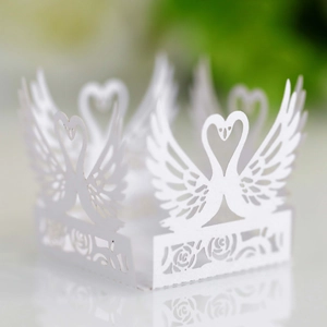 Detail of white laser-cut swan heart wedding candy box with intricate rose patterns