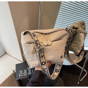 Detail of off-white nylon crossbody bag featuring a wide printed floral shoulder strap