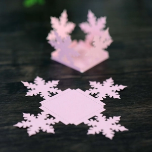 Macro shot of laser-cut pink snowflake candy box with elegant pearlescent paper finish