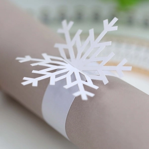 Macro view of white snowflake napkin ring with laser-cut hollow pattern for table decor