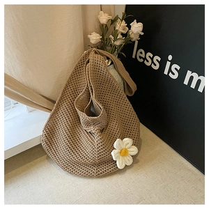 Gros plan sur la texture du sac tressé avec un pendentif fleur de marguerite blanche