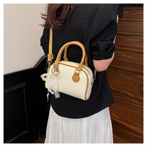 Detail of white lychee pattern Boston bag with yellow accents and pearl lace bow charm