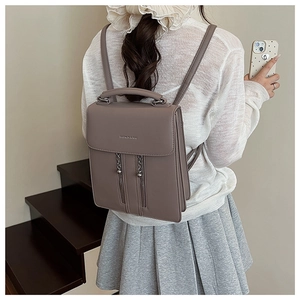 Detail of taupe PU leather backpack showing flap closure, metal chains and zippers