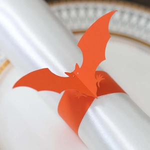 Detail of laser-cut orange bat napkin ring made of cardstock for Halloween decor