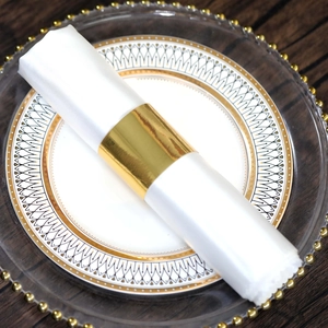 Elegant gold metal napkin ring on white linen napkin for upscale table decoration