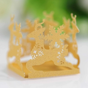 Close-up of laser-cut gold reindeer and snowflake paper lantern with hollow details