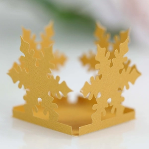 Detailed macro view of laser-cut golden snowflake paper ornaments for festive party decor