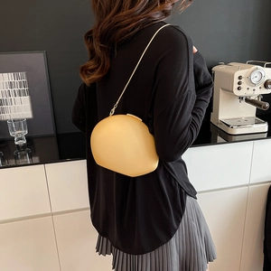Sac bandoulière minimaliste jaune en forme d'œuf dans un cadre de café élégant et moderne