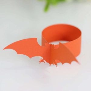 Close-up of laser-cut orange paper bat napkin ring for Halloween table decoration