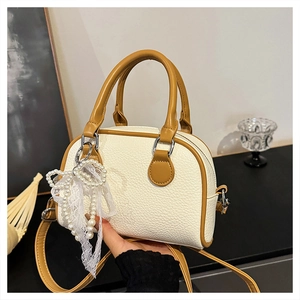 Close-up of cream white lychee leather texture and lace pearl bow on Boston bag