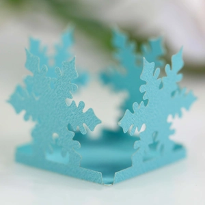 Macro shot of sky blue hollowed-out snowflake paper wrap with laser-cut textures