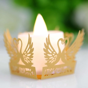 Macro view of champagne gold swan hollow laser-cut tea light candle paper holder