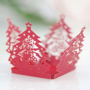 Macro shot of red laser-cut Christmas tree paper box with star and bell hollow patterns
