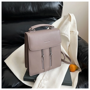 Detail of grey-purple square bag with silver chains and FASHION & BAG print