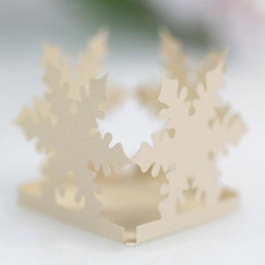 Close-up of laser-cut hollow snowflake paper box decoration in creamy white finish