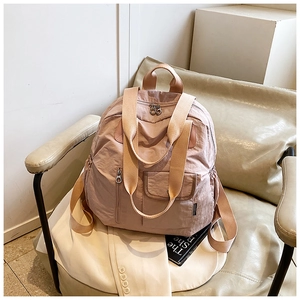 Close-up of pink nylon travel backpack with waterproof texture and wide straps