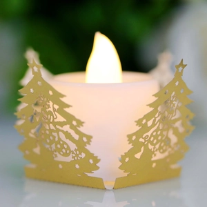 Détail macro de bougie LED avec cache décoratif doré ajouré aux motifs de sapin de Noël