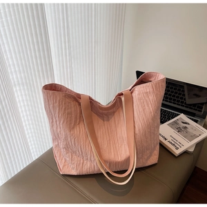 Detail of pink pleated texture tote bag with wide handle on life-style background