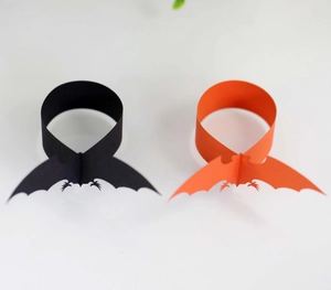 Close-up of laser-cut Halloween bat napkin rings in black and orange paper finish