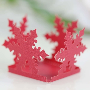 Macro shot of red laser-cut snowflake hollow gift box detail for Christmas and wedding