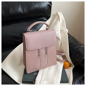 Detail of dusty rose PU leather handbag with metal ball chain and top handle