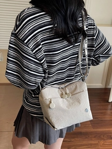 Light beige nylon crossbody bag with wide patterned strap and multiple zipper pockets