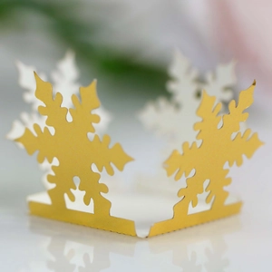 Detailed macro view of hollow snowflake paper lantern with intricate cutout gold and white patterns
