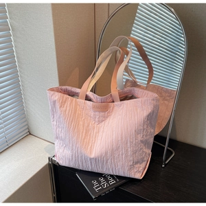 Detailed macro view of pink pleated fabric tote bag with JUMAITU brand leather label