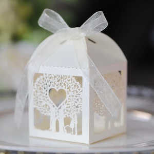 Λεπτομέρειες laser-cut δέντρο καρδιάς σε λευκό κουτί γλυκών γάμου με κορδέλα