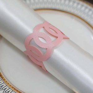 Macro shot of laser-cut pink paper napkin ring with elegant hollow geometric pattern