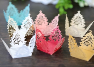 Detailed laser-cut paper Christmas tree tea light covers in various vibrant colors