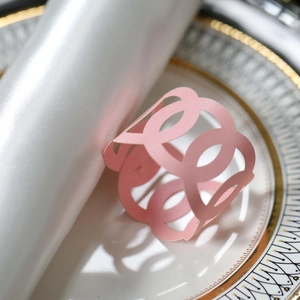 Detailed macro view of laser-cut pink paper napkin ring with hollow circular patterns
