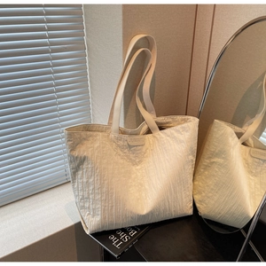 Detail of off-white tote bag showing pleated texture and JUMAITU leather brand tag