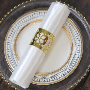 Close-up of golden snowflake napkin ring with镂空 design on white satin napkin