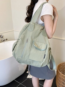 Minimalist light green nylon travel backpack with multi-pocket design and pleated texture