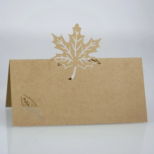Detailed laser-cut maple leaf kraft paper place card showing intricate cutout veins