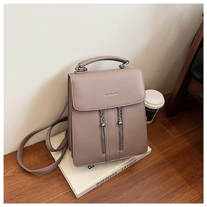 Detail of light coffee leather backpack with decorative zippers on a lifestyle background