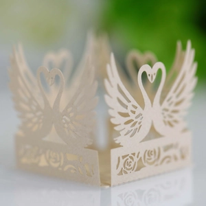 Detailed laser-cut ivory cupcake wrapper featuring elegant swans and rose patterns