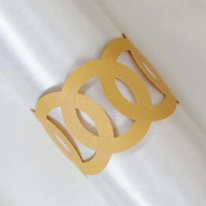 Close-up of golden laser-cut paper napkin ring with hollow geometric circle pattern