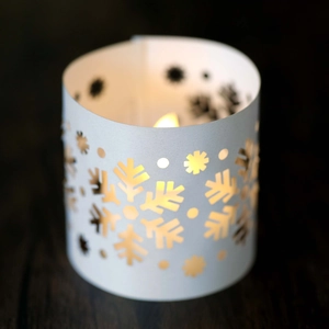 Detail of white snowflake hollow paper lampshade with warm LED candle light effect