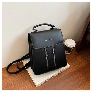 Detail of black lychee grain leather backpack with dual vertical zippers and top handle