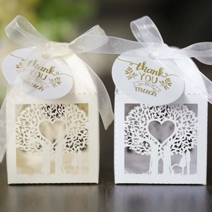 Close-up of laser-cut heart tree gift boxes with ribbon and thank you tags