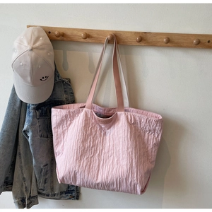 Detail of pink large-capacity tote bag with textured fabric and JUMAITU logo