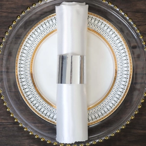 Silver mirror napkin ring on white satin napkin for elegant restaurant table setting