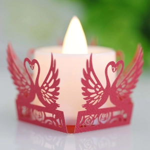 Close-up of a red swan heart laser-cut paper lampshade with a warm LED tea light candle