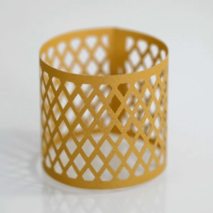 Macro detail of golden lattice napkin ring featuring laser-cut diamond hollow patterns