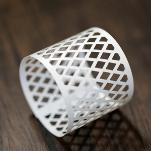 Detailed view of white hollow lattice paper lampshade with diamond grid on wood background