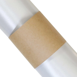 Macro shot of white textured napkin ring with brown kraft paper wrap and subtle glitter