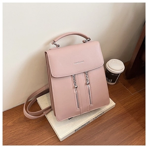 Detail of dusty pink PU leather backpack showing top handle and fashion text engraving